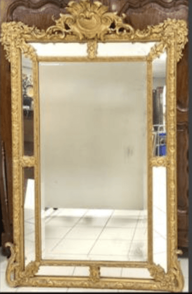 A rectangular mirror with an ornate, gilded frame. The frame features intricate carvings and decorative elements, including scrolling acanthus leaves and a cartouche at the top. The mirror surface appears to be glass. — 3D model