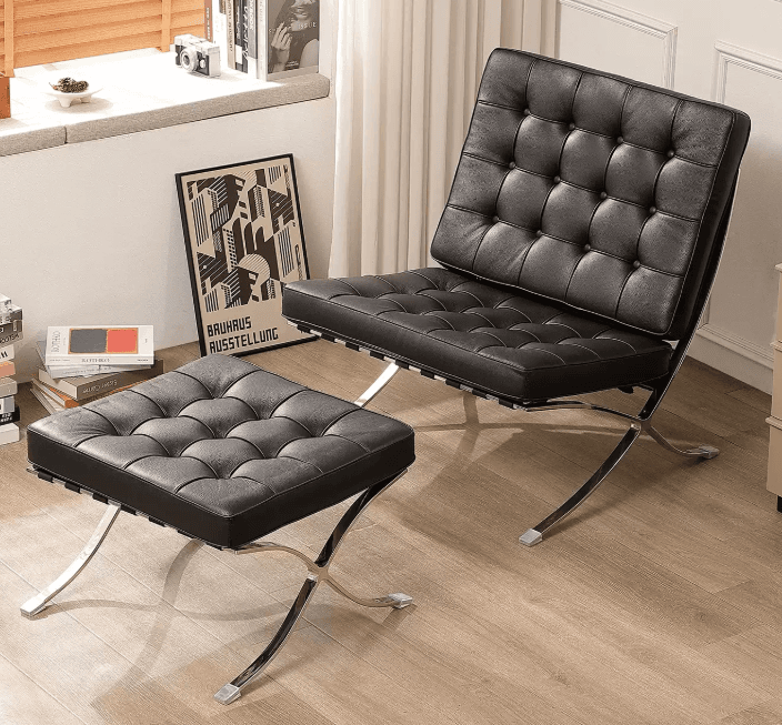 An iconic Mid-Century Modern lounge chair and its matching ottoman, known as the Barcelona Chair and Ottoman. It features a polished chrome-plated flat steel frame with a distinctive X-shaped base and generously proportioned, deeply tufted black leather cushions. — 3D model