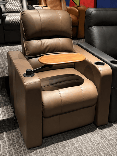 A contemporary brown upholstered chair, likely a recliner, featuring a plush backrest, seat, and armrests. It includes an integrated cup holder and a detachable or swiveling wooden side table. — 3D model