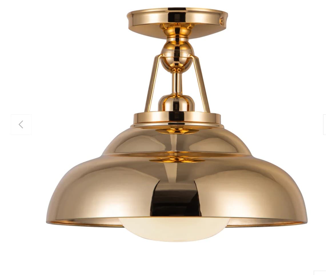 A polished brass semi-flush mount ceiling light featuring a dome-shaped shade with a gleaming, reflective surface. The fixture attaches to the ceiling via a mounting plate and a decorative stem with articulating joints, allowing for a subtle adjustment in its positioning. A frosted glass diffuser at the bottom emits a soft, ambient light. The overall design blends classic dome aesthetics with industrial-inspired hardware, rendered in a luxurious, high-shine brass finish. — 3D model