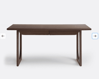 A wooden desk with a simple, modern design. It features a rectangular tabletop with slightly rounded edges and two drawers integrated into the front. The desk is supported by two curved legs on each side, creating an open base structure. The wood grain is visible, suggesting a natural wood finish. — 3D model
