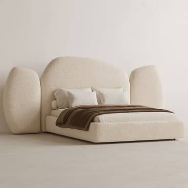 A contemporary platform bed featuring a low-profile base and an oversized, sculptural headboard with integrated side panels, all upholstered in a textured bouclé fabric. The design emphasizes soft, rounded forms and a monochromatic off-white color palette, giving it a minimalist yet plush aesthetic. It is styled with simple white bedding and a brown throw blanket. — 3D model