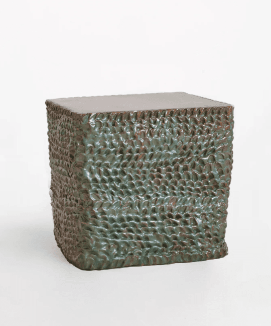 A cube-shaped accent table featuring a heavily textured surface with a dark green, mottled glaze, and a flat, smooth top. — 3D model