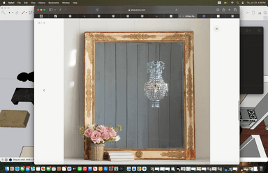 A rectangular wall mirror featuring an ornate, distressed gilded frame. The frame has prominent decorative carvings along its edges, with a cream-colored base showing through the aged gold finish. The mirror surface reflects what appears to be a crystal chandelier and a grey panelled wall, indicating its reflective quality. — 3D model