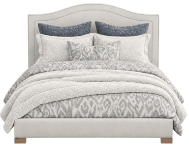 An upholstered bed featuring a subtly scalloped headboard, a low-profile frame, and a neutral color palette. The bed is adorned with coordinated bedding in shades of white, grey, and blue. — 3D model