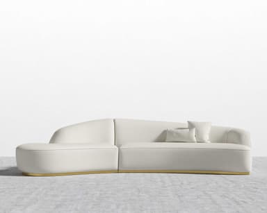 A modern curved sectional sofa upholstered in light bouclé fabric with a recessed gold-finished plinth base, designed for contemporary living spaces. — 3D model