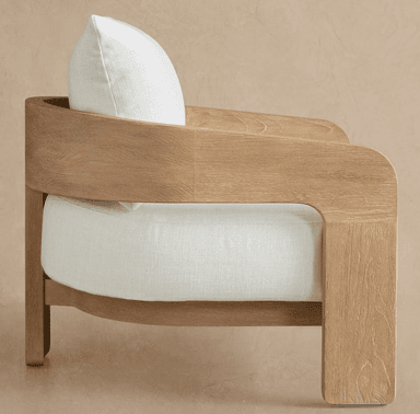 A modern upholstered armchair featuring a light-toned wooden frame and thick, cream-colored fabric cushions. The frame exhibits a prominent natural wood grain texture and gently curved armrests. — 3D model