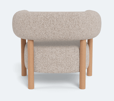 A single accent chair featuring a rounded, enveloping backrest and seat upholstered in a textured, light-colored boucle or similar fabric. The chair is supported by a minimalist frame constructed from light-toned wood, with four cylindrical legs extending from the base and two upright supports that integrate into the armrests and connect to the backrest. The design blends soft, organic curves with a clean, natural material aesthetic. — 3D model