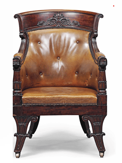 A classical armchair with a curved, tufted leather seat and back, upholstered with brass tack detailing. The wooden frame is dark stained and features carved decorative elements on the crest rail, armrests, and legs. The chair is supported by four carved legs, two of which have brass casters. — 3D model