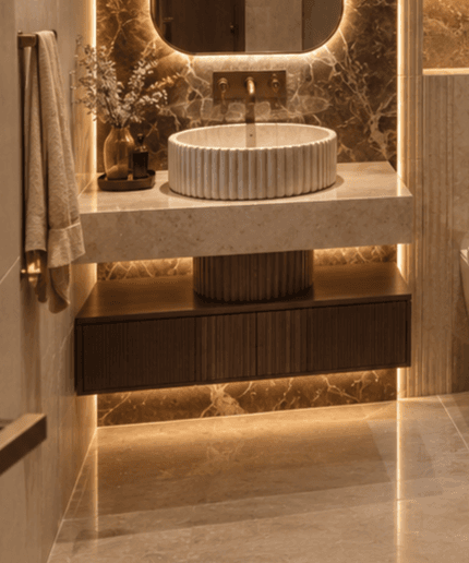 A modern wall-mounted bathroom vanity featuring a dark fluted wood cabinet, a beige marble countertop, and a matching fluted marble vessel sink, accompanied by a brass faucet. — 3D model