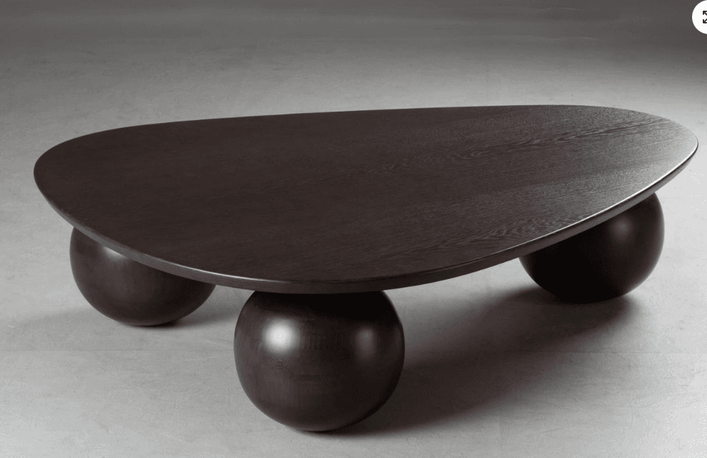 A modern coffee table featuring an irregularly shaped, organic tabletop supported by three robust, spherical legs. The entire piece is constructed from dark-stained wood, possibly oak or ash, with a visible grain texture. — 3D model