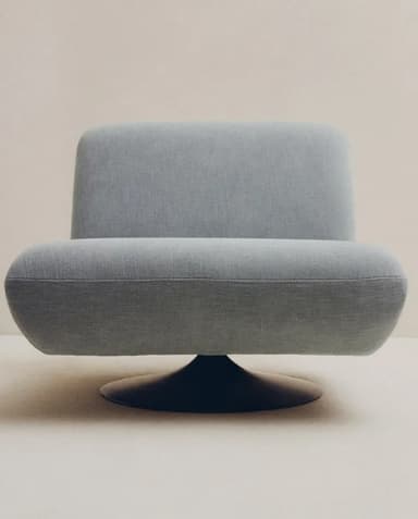 An armless upholstered lounge chair featuring a low-profile, minimalist design with a concealed swivel base. The chair is fully upholstered in a light grey-blue textured fabric, presenting a modern aesthetic. — 3D model