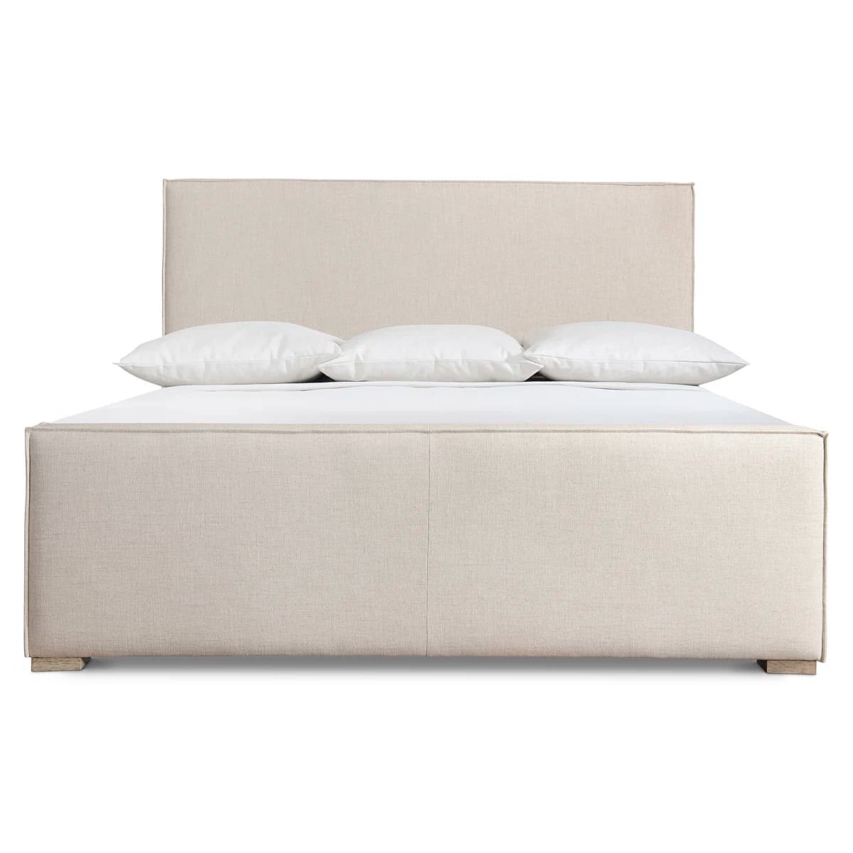 A upholstered bed frame with a rectangular headboard and a low profile footboard. The frame is covered in a textured, light beige fabric. It features a solid headboard and a platform base supported by short, light-colored wooden legs visible at the bottom corners. Three white pillows are placed on the headboard. — 3D model
