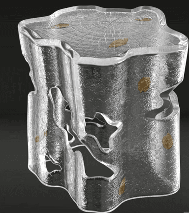 A sculptural accent table or stool crafted from clear, textured resin, designed to resemble a block of ice or a natural tree stump. The piece features an organic, irregular silhouette with cut-out sections in its body, giving it a light, ethereal appearance. Embedded within the clear material are small, delicate golden leaf inclusions. The top surface is flat but textured with an embossed wood grain pattern, suggesting tree rings, further enhancing its nature-inspired aesthetic. The overall impression is one of modern artistry combined with natural elements. — 3D model