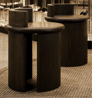 A dark-stained wooden stool featuring a round seat and a low, curved backrest, supported by a monolithic cylindrical base. — 3D model