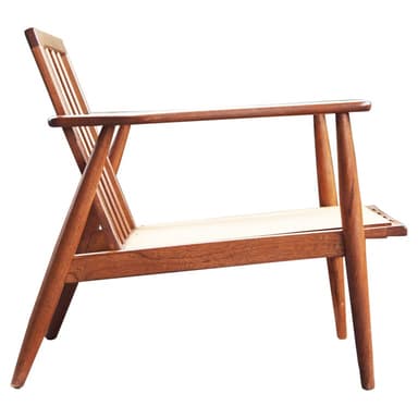 A classic Mid-Century Modern armchair featuring a warm-toned wooden frame with a slatted backrest and integrated armrests. The seat is constructed from a light-colored woven material, likely cane, providing a natural and breathable surface. The chair exhibits clean lines and tapered legs, characteristic of Scandinavian design principles. — 3D model