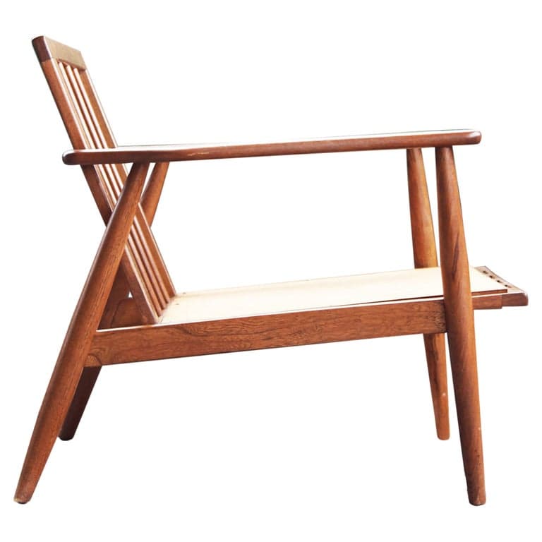 A classic Mid-Century Modern armchair featuring a warm-toned wooden frame with a slatted backrest and integrated armrests. The seat is constructed from a light-colored woven material, likely cane, providing a natural and breathable surface. The chair exhibits clean lines and tapered legs, characteristic of Scandinavian design principles. — 3D model