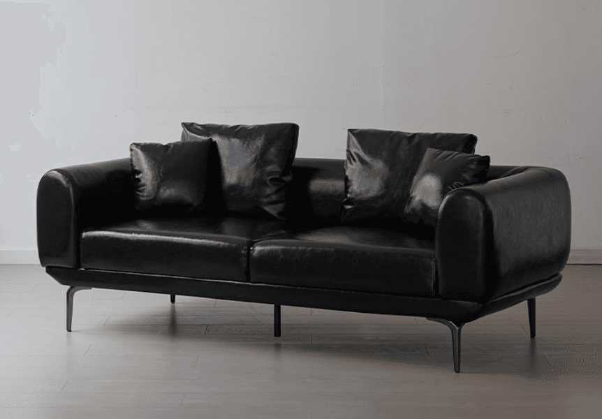 A contemporary two-seater loveseat upholstered in black faux leather, featuring rounded armrests and loose back cushions. It is supported by sleek, splayed metal legs in a dark finish. — 3D model