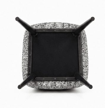 A contemporary upholstered armchair featuring a black, smoothly curved backrest and integrated armrests. The seat cushion is upholstered in a contrasting white and gray patterned fabric. The chair is supported by four dark, tapered wooden legs, lending it a sleek and modern appearance. — 3D model
