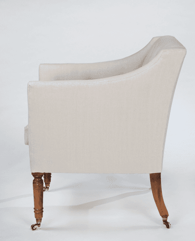 A tufted armchair with a high back and rolled arms, upholstered in a light-colored fabric. It features wooden legs with brass casters. — 3D model