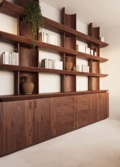 A large, modular wooden shelving unit with an integrated base cabinet. The shelving unit features multiple horizontal shelves supported by vertical and curved elements, creating a dynamic display. The base unit comprises several cabinets with flush doors and drawers, offering ample storage space. A hanging plant adds a natural element to the top shelf. — 3D model