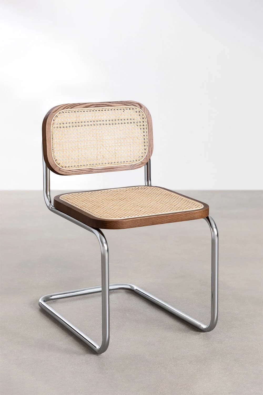 A modern cantilever dining chair featuring a tubular chrome frame, a dark-stained wood and cane webbing seat, and a matching cane webbing backrest with rounded wooden edges. — 3D model
