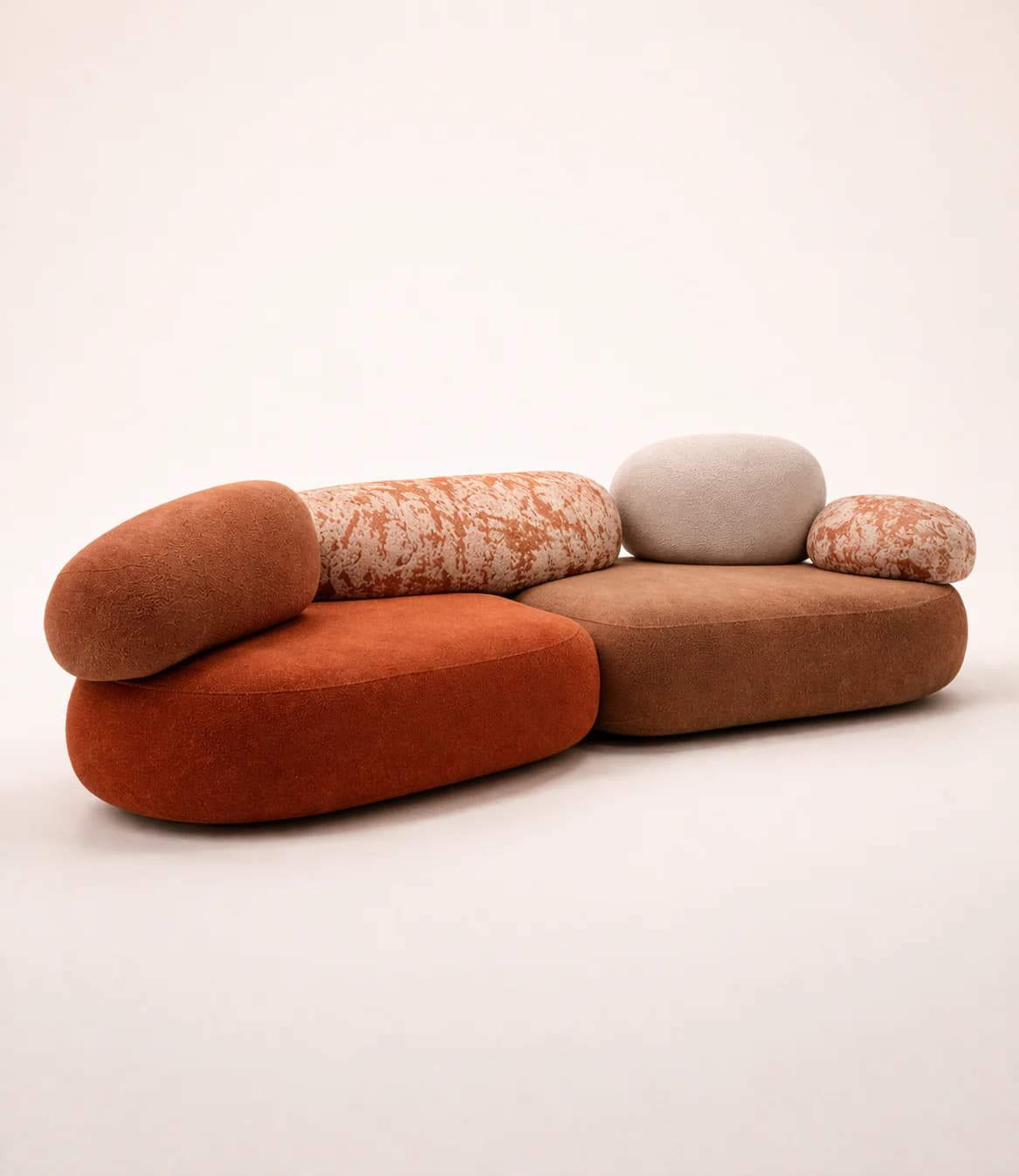 A multi-part modular sectional sofa designed with organic, pebble-like shapes and upholstered in a combination of textured fabrics in earthy tones of rust, brown, and light beige. The individual components, which vary in size and color, fit together to form a unique, flowing seating arrangement. — 3D model