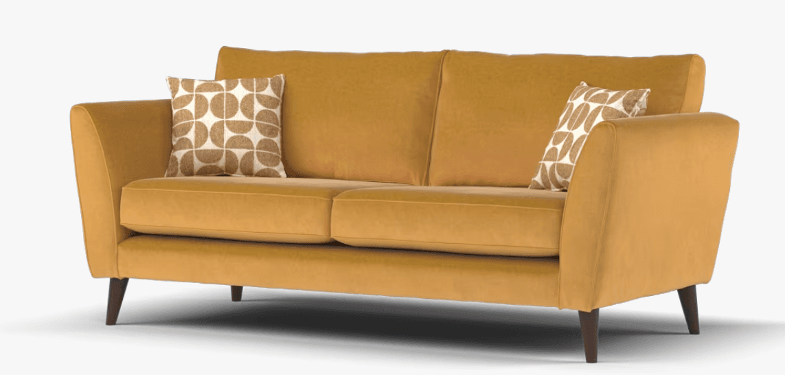 A mustard yellow two-seater loveseat upholstered in velvet, featuring a clean-lined, mid-century modern design. It includes two seat cushions and two back cushions, supported by four tapered wooden legs. Two decorative accent pillows with a geometric pattern are placed on the sofa. — 3D model