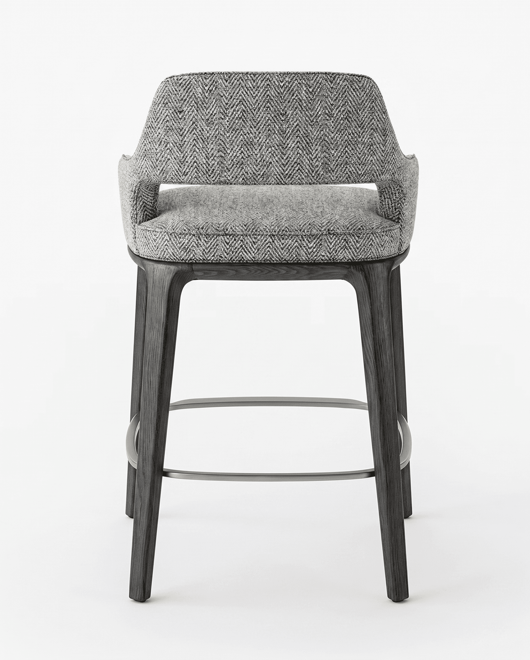 A modern bar stool with a fabric-upholstered seat and backrest, supported by dark-stained wooden legs. The stool features a curved back and armrests integrated into the main body. A metal footrest connects the four legs. — 3D model
