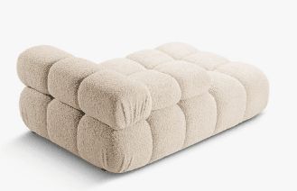 A contemporary chaise lounge featuring an innovative design with multiple rounded, pillow-like upholstered segments. The piece is finished in a light beige or off-white fabric, providing a plush and inviting aesthetic. It integrates a low backrest and a small armrest on one side, contributing to its modular appearance and ergonomic comfort. The chaise rests on discreet, low-profile feet. — 3D model