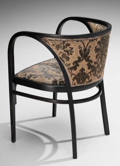 A dark-stained bentwood armchair featuring a distinctive barrel-back design. The frame is constructed from elegantly curved wood, forming integrated armrests and a supportive backrest. Both the seat and the inner backrest are upholstered in a patterned fabric, displaying a traditional damask or paisley motif in shades of dark brown/black and beige/gold. The chair stands on four straight legs, connected by simple stretchers for stability. The overall aesthetic suggests an early 20th-century or classic design. — 3D model