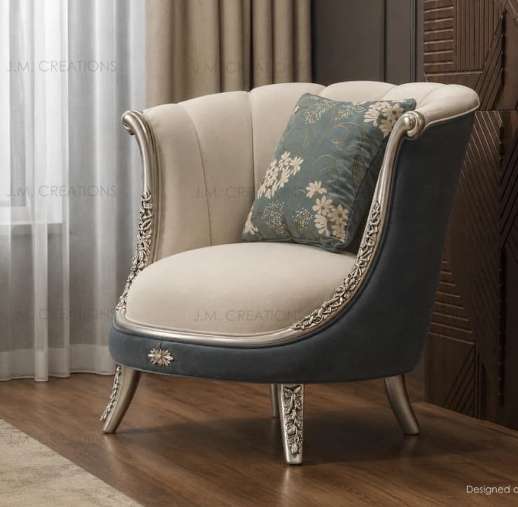 An ornate upholstered armchair showcasing a Baroque Revival aesthetic. It features a shell-like, channel-tufted backrest and a fixed seat cushion, both covered in a light cream or beige fabric. The exterior of the back and sides is upholstered in a contrasting dark teal or gray fabric. The chair's frame, including the armrests and cabriole-style legs, is intricately carved with acanthus leaf motifs and finished in a metallic silver or champagne tone, highlighting its decorative nature. A floral patterned throw pillow in coordinating colors accompanies the chair. — 3D model