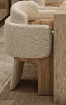 A contemporary armchair featuring a rounded, upholstered seat and back in off-white boucle fabric, supported by a distinctive light wood frame that forms the front legs and wraps around the sides of the backrest. — 3D model