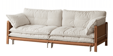 A contemporary three-seater sofa featuring a robust light-toned wooden frame and generously padded, tufted cushions upholstered in a cream-colored fabric. The design includes an exposed rectangular wood frame for the base and armrests, with cylindrical metal legs providing support. The cushions are thick, with piped edges, and offer a low-profile, relaxed seating experience. — 3D model