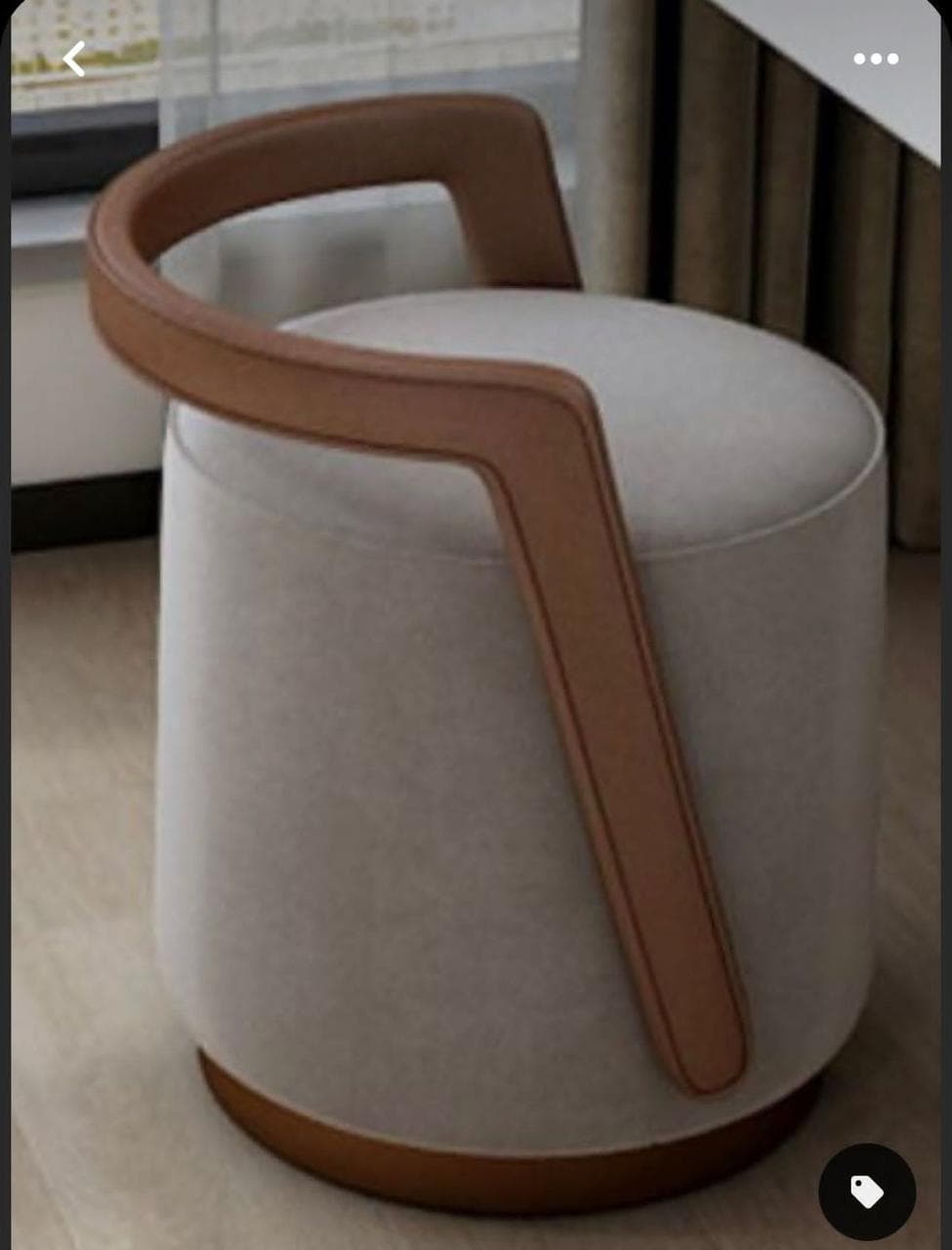 A contemporary cylindrical upholstered stool featuring a distinctive U-shaped brown leather handle that doubles as a low backrest. The main body is covered in a light beige textured fabric, and it rests on a dark brown circular base. — 3D model