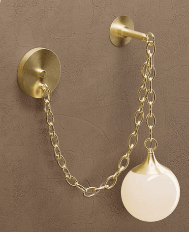 A modern wall-mounted light fixture, characterized by its brass construction and a frosted spherical glass shade, suspended by a decorative brass chain. — 3D model
