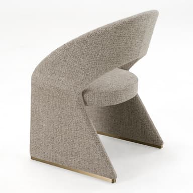 A contemporary, fully upholstered accent chair featuring a distinctive sculptural form. The backrest curves continuously, seamlessly integrating with the solid, geometric base. It is covered in a textured, light beige fabric, and subtle brass accents are visible at the bottom of the base. — 3D model