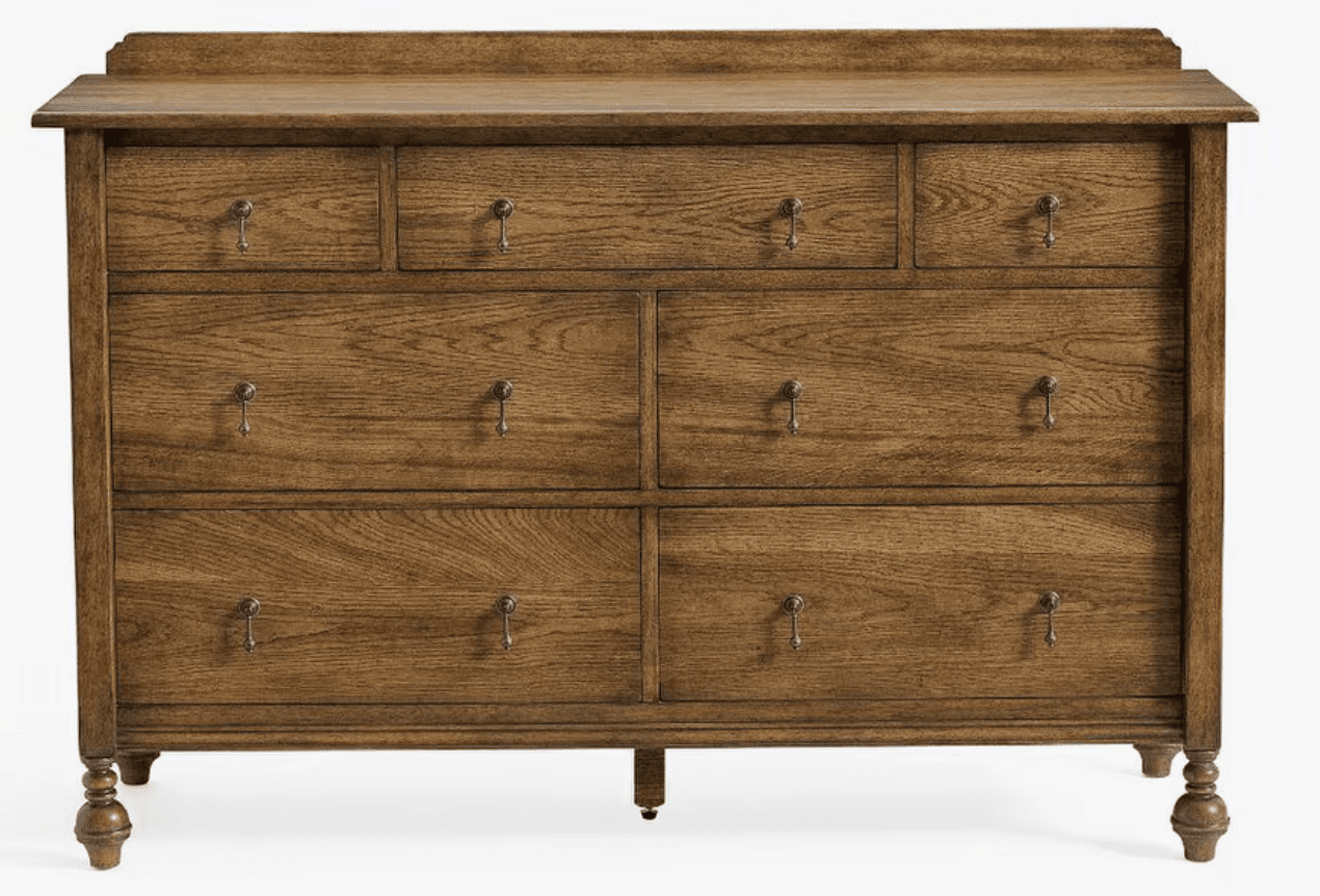 A wooden dresser with multiple drawers. It features a top surface with a raised edge, and a series of drawers of varying sizes arranged in a grid. The drawers are equipped with simple, metallic pull handles. The dresser stands on four turned legs, with the front legs having a more decorative, bulbous shape. — 3D model