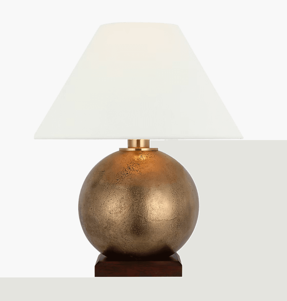 A table lamp featuring a spherical, textured bronze-finished body, supported by a square dark wood base, and topped with a clean white tapered drum lampshade. A polished brass accent ring connects the base and shade. — 3D model