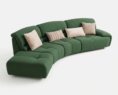 A modular, curved sectional sofa upholstered in a textured, dark green fabric. The sofa features deep seat cushions with tufted detailing, creating a series of square segments. It includes a chaise lounge extension on the left side. Several throw pillows are placed on the sofa: two in a soft pink, one with brown and beige stripes, and one in a textured beige fabric. — 3D model