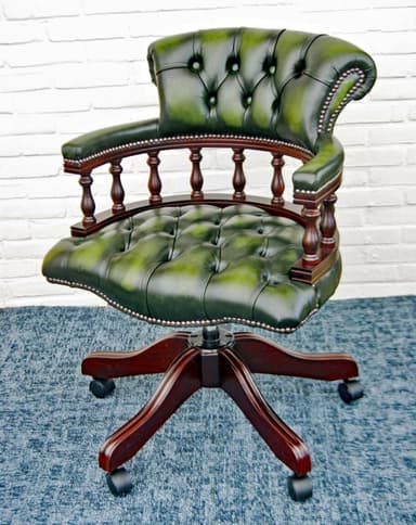 A classic green leather office chair featuring a deep tufted back and seat, traditional turned wooden armrests, and a dark wood five-star swivel base with casters. The leather has a slightly distressed, antique appearance, accented with decorative nailhead trim along the edges of the upholstery and armrests. — 3D model