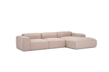 A sectional sofa with a chaise lounge extension. The sofa features a low profile, clean lines, and deep, plush seating. It is upholstered in a textured, neutral-toned fabric. The design appears modular or composed of distinct sections. — 3D model