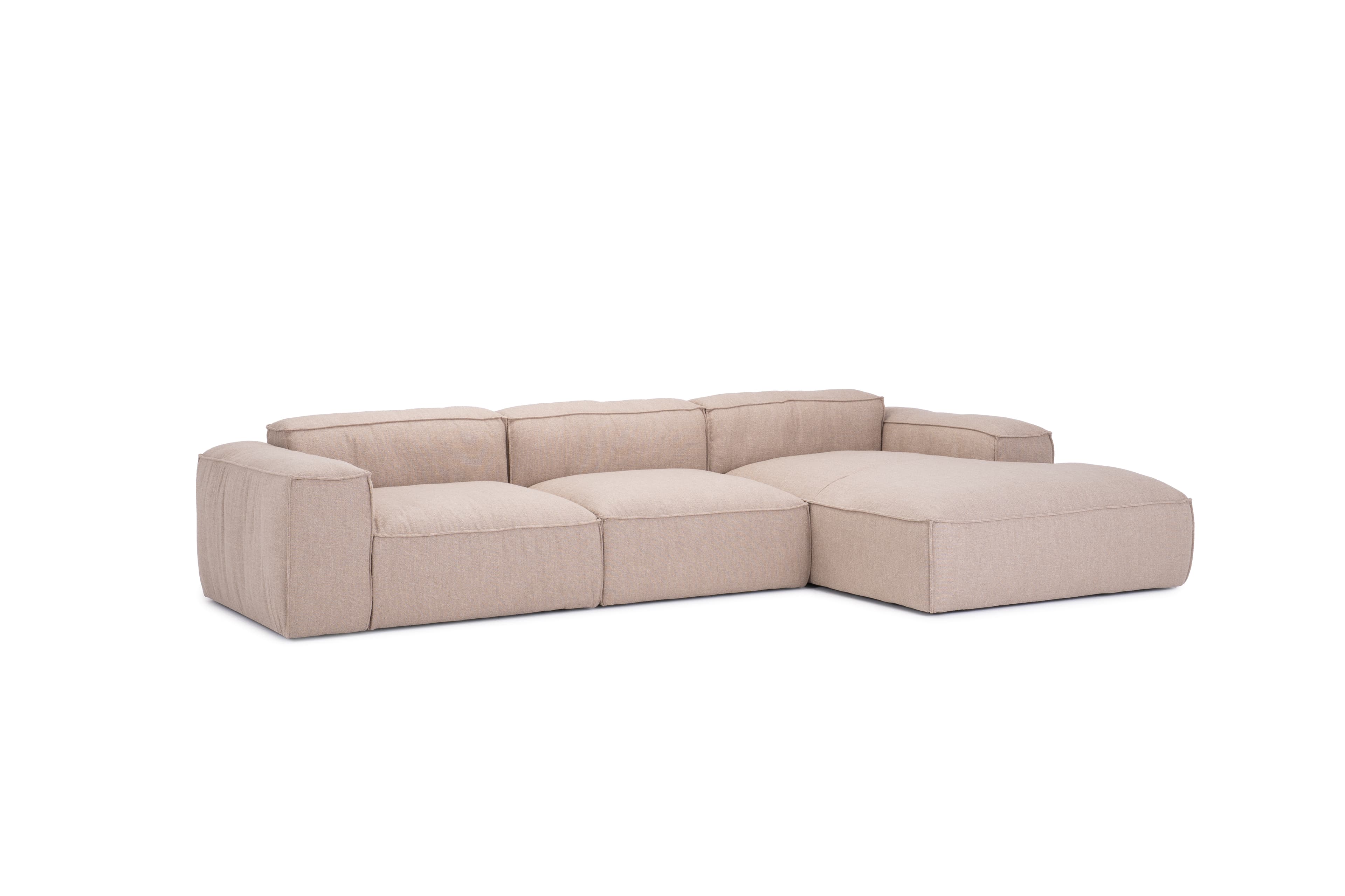 A sectional sofa with a chaise lounge extension. The sofa features a low profile, clean lines, and deep, plush seating. It is upholstered in a textured, neutral-toned fabric. The design appears modular or composed of distinct sections. — 3D model