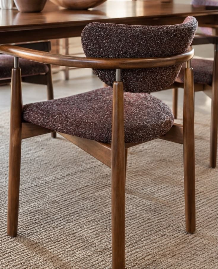 A contemporary dining armchair featuring a dark brown wooden frame, integrated armrests, and speckled brown fabric upholstery on the seat and curved backrest. — 3D model