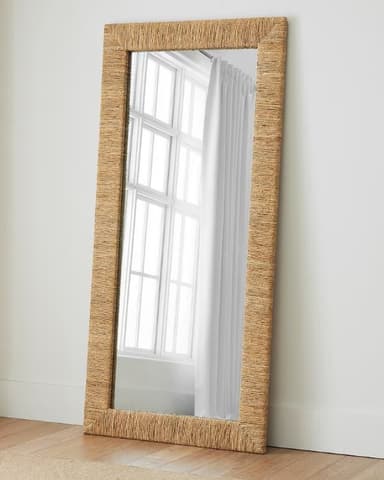 A rectangular wall mirror featuring a frame constructed from tightly woven natural fibers, likely jute or seagrass, in a light brown, natural hue. The mirror has a clean, unframed reflective surface set within the textured border. — 3D model