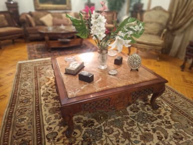 A square, traditional coffee table featuring a polished brown marble top with white and lighter brown veining. The base and four cabriole legs are crafted from dark brown hardwood, intricately carved with floral and geometric openwork patterns along the apron and detailed motifs on the legs. — 3D model