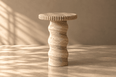 A sculptural pedestal table crafted from travertine. It features a circular top with a fluted edge and a wavy, organic-shaped central base, showcasing the natural variations and textures of the stone. — 3D model