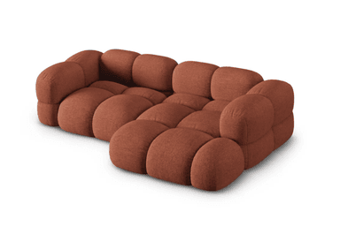 A modular sofa with a rounded, puffy design, featuring distinct individual cushions for the seat and backrest. The sofa appears to be upholstered in a textured fabric and is configured in an L-shape, with an armrest on the left side. — 3D model