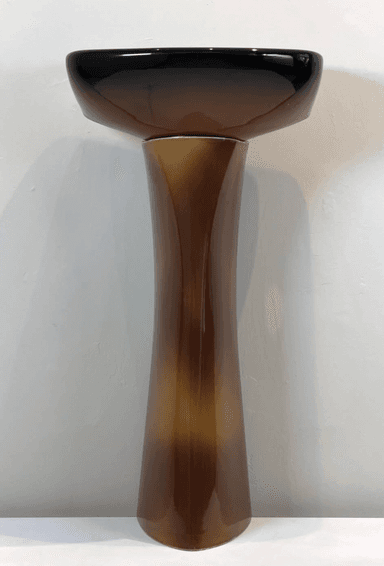 A contemporary pedestal sink featuring a striking ombré finish that transitions from dark black at the rim to a warm, glossy brown in the basin and down the pedestal. The basin has an elliptical shape with a single faucet hole and an integrated overflow slot. The pedestal base tapers elegantly from the basin to the floor, contributing to a sleek and modern aesthetic. — 3D model