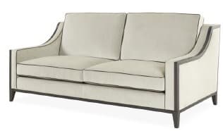 A transitional two-seater sofa featuring an exposed dark wood frame that defines its silhouette. The sofa is upholstered in a light, neutral fabric, likely linen or a blend, with dark contrast piping along the edges of the seat and back cushions, as well as the sofa's body. It has two loose seat cushions and two loose back cushions. The arms are gently curved, forming a sleek, architectural line that integrates with the backrest. Tapered legs are part of the exposed frame structure. — 3D model